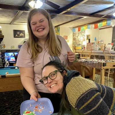 Two people smiling with a plate of holiday cookies