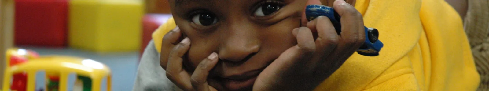 a young boy holding a toy car